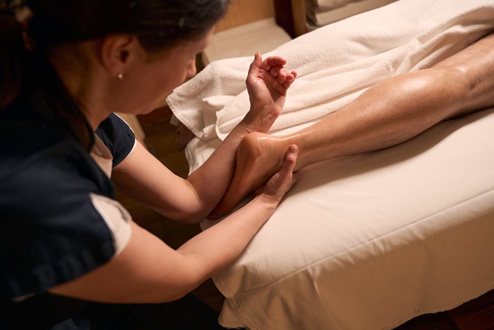 woman massaging a man s leg in indoor setting 2026 01 05 06 25 18 utc scaled